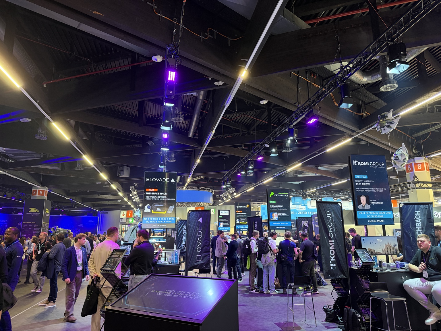 Visitors among technology vendor stands in an it-sa 2026 exhibition hall