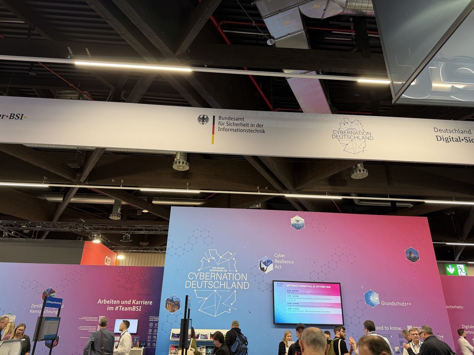 Visitors at the BSI stand with Cybernation Deutschland signage at it-sa 2026